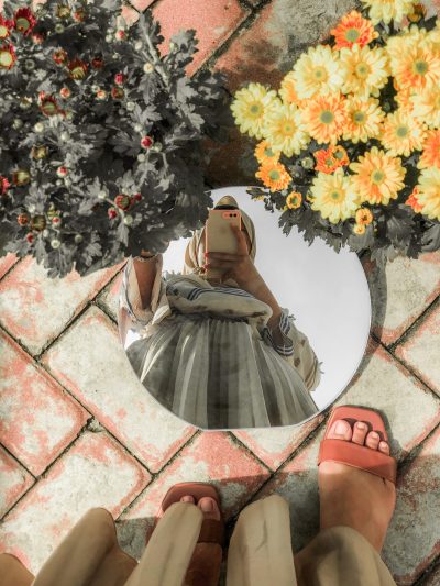 seccion-baja-de-la-mujer-de-pie-junto-las-plantas-con-flores